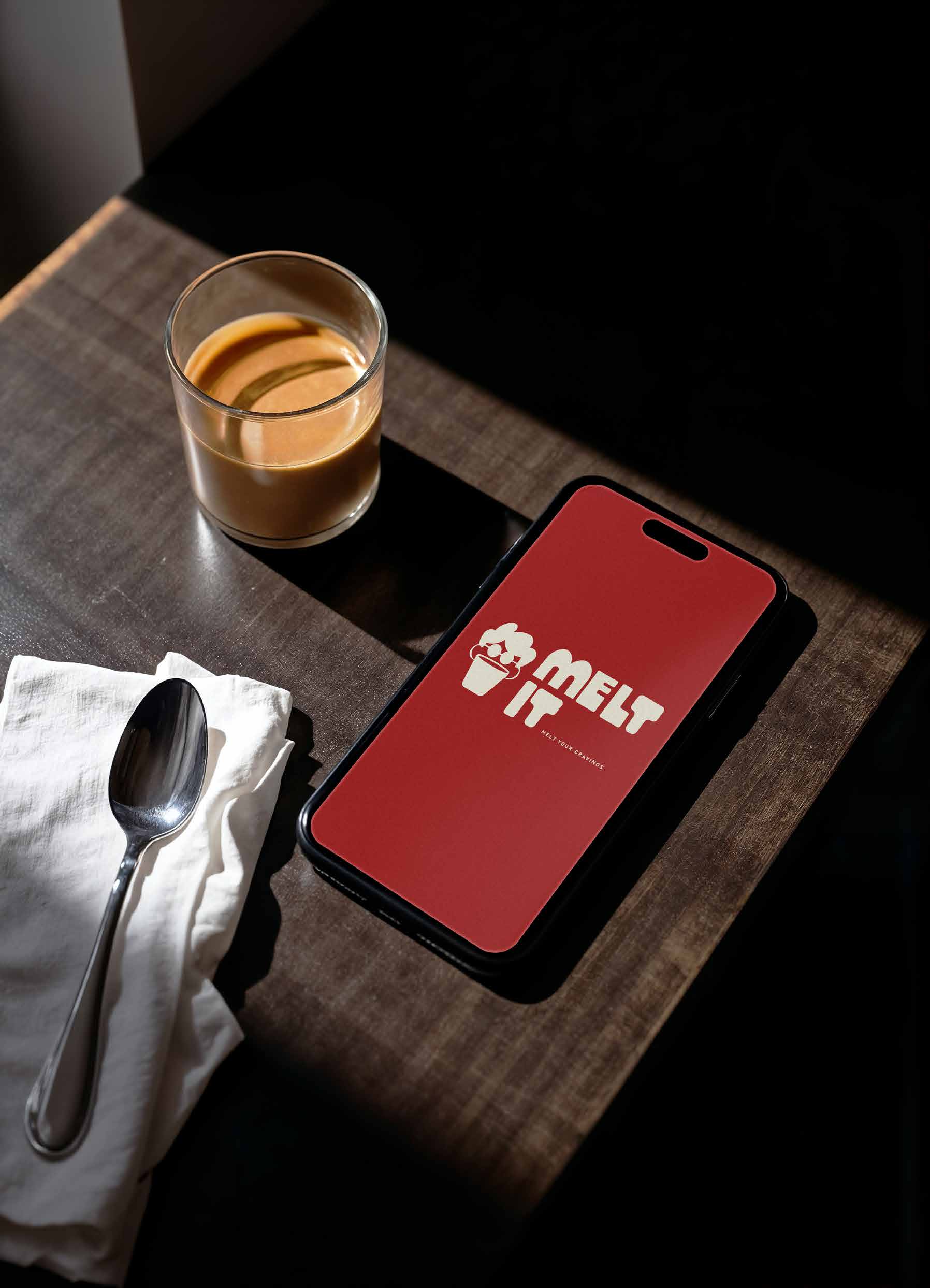MELT IT app on a phone next to coffee